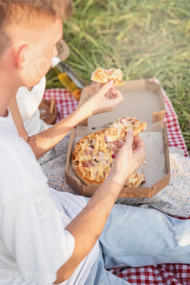 ungt par som har picknick på solrosfältet vid solnedgången foto