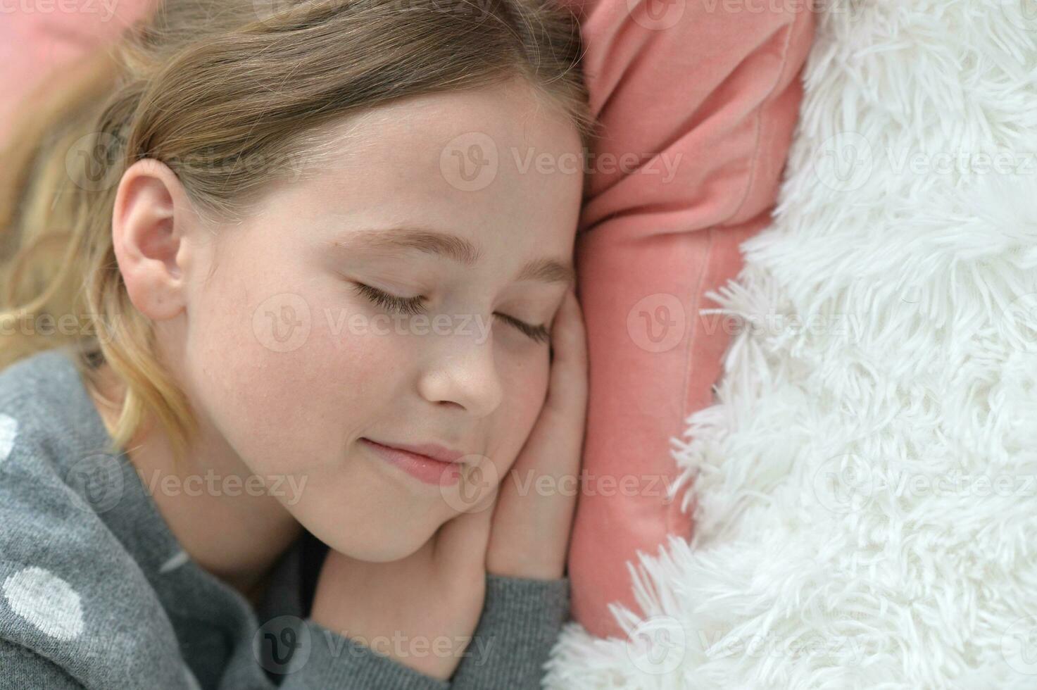 ljuv liten flicka sovande i en säng foto