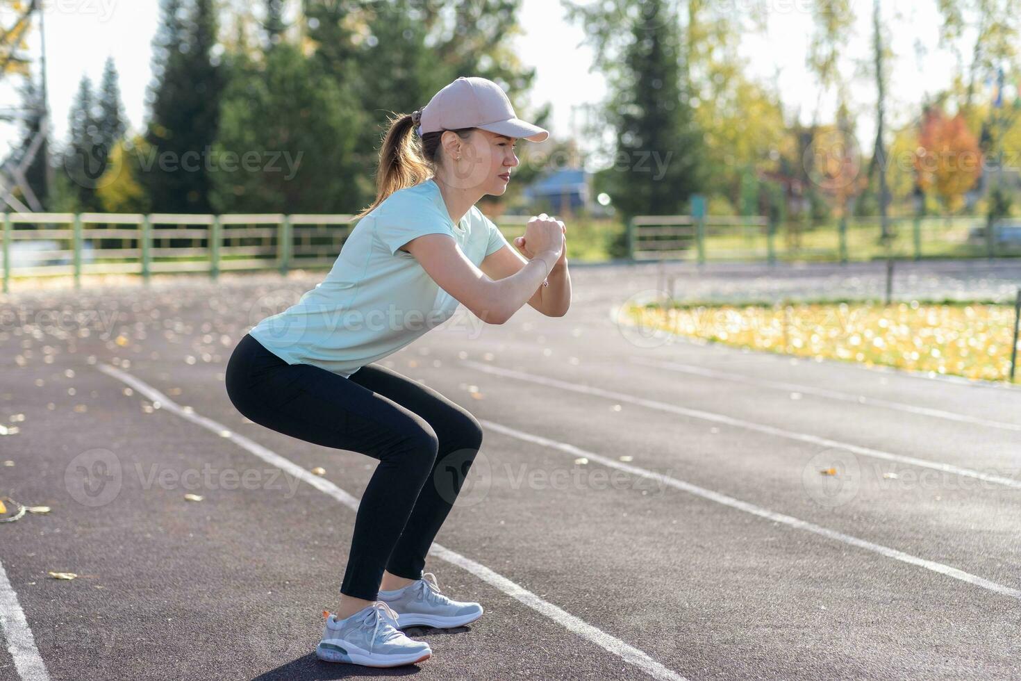 en ung skön kvinna i sportkläder spelar sporter på en lokal- stadion foto