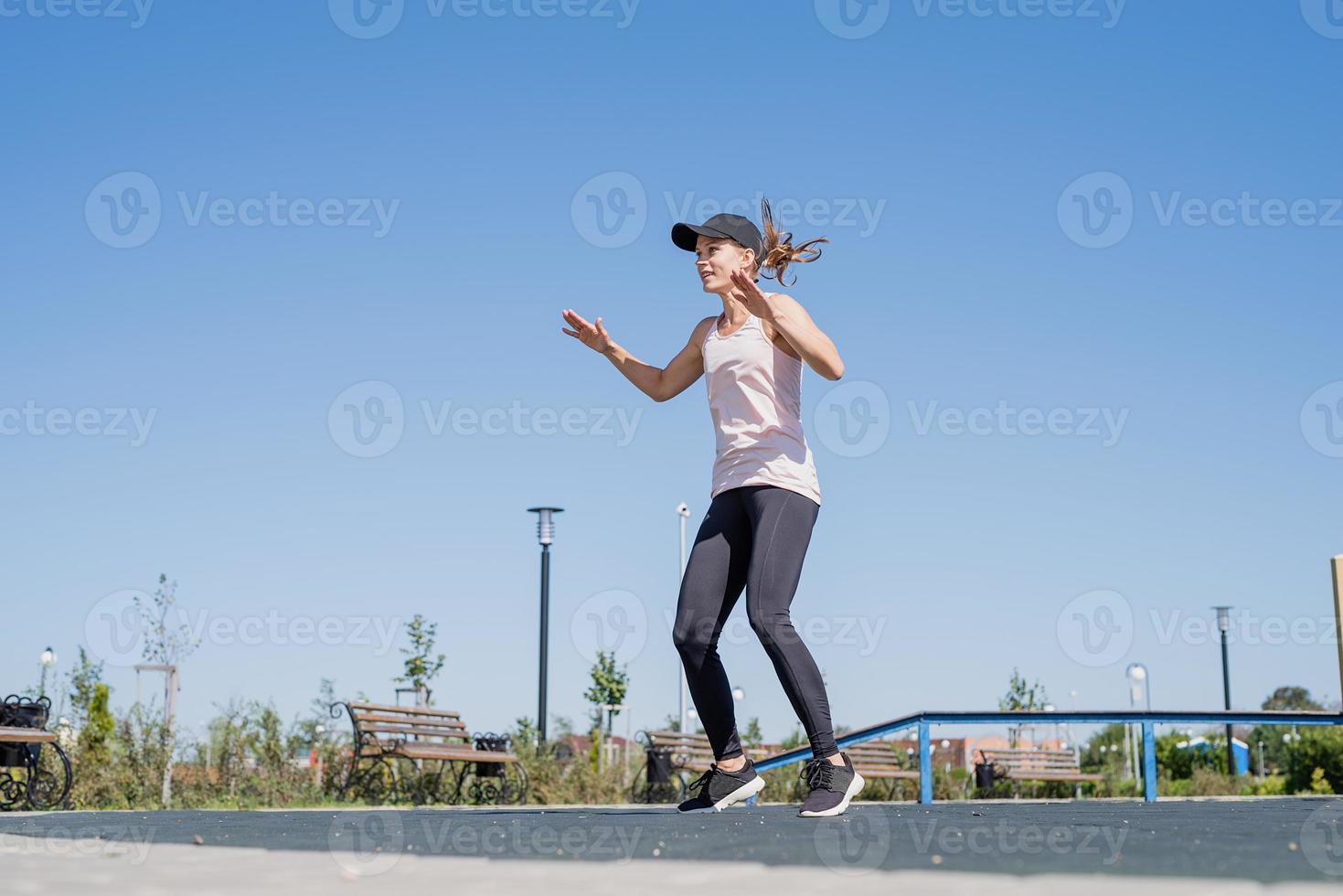 sportig kvinna som tränar på idrottsplatsen under en solig sommardag foto