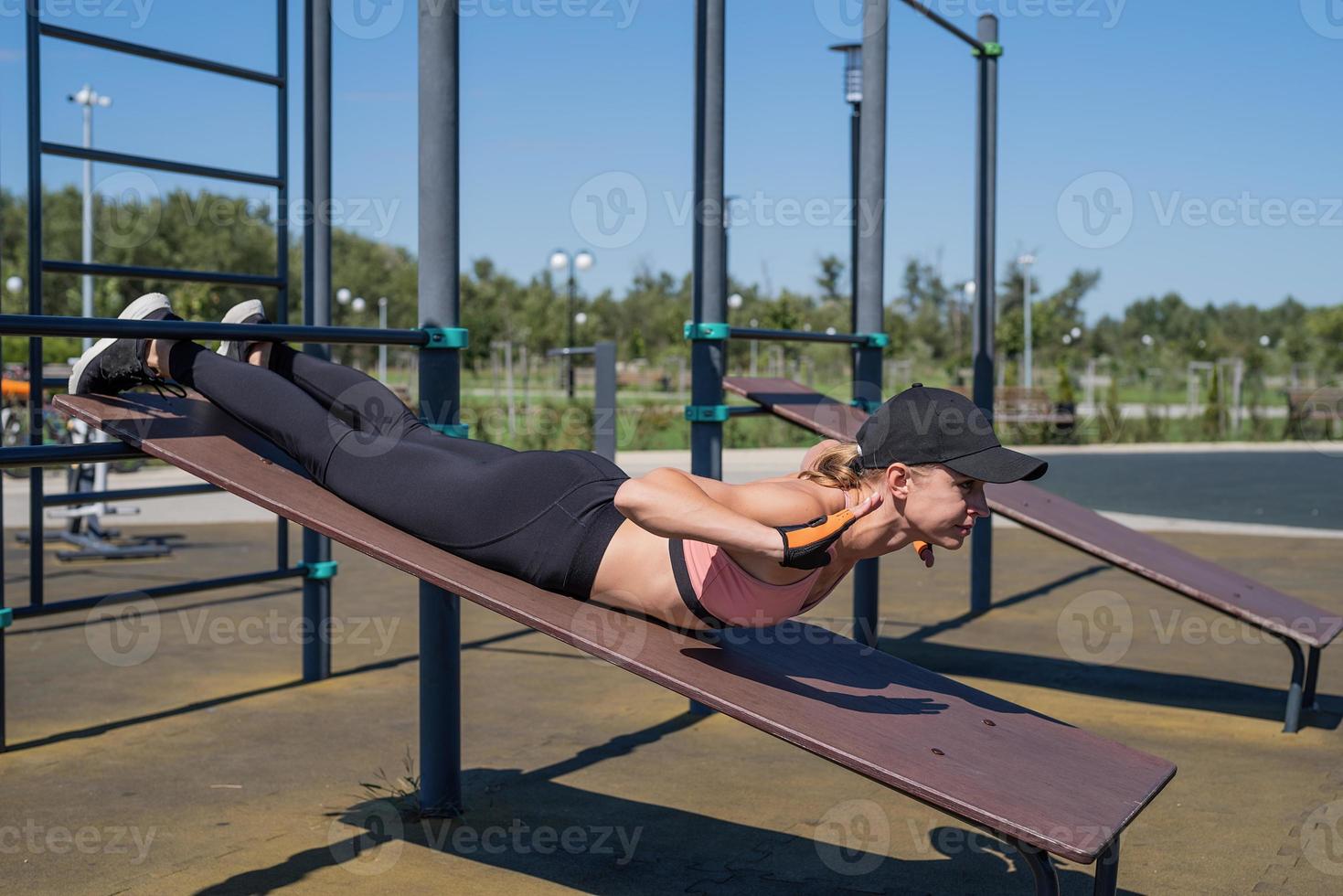 sportig kvinna som tränar på idrottsplatsen under en solig sommardag foto