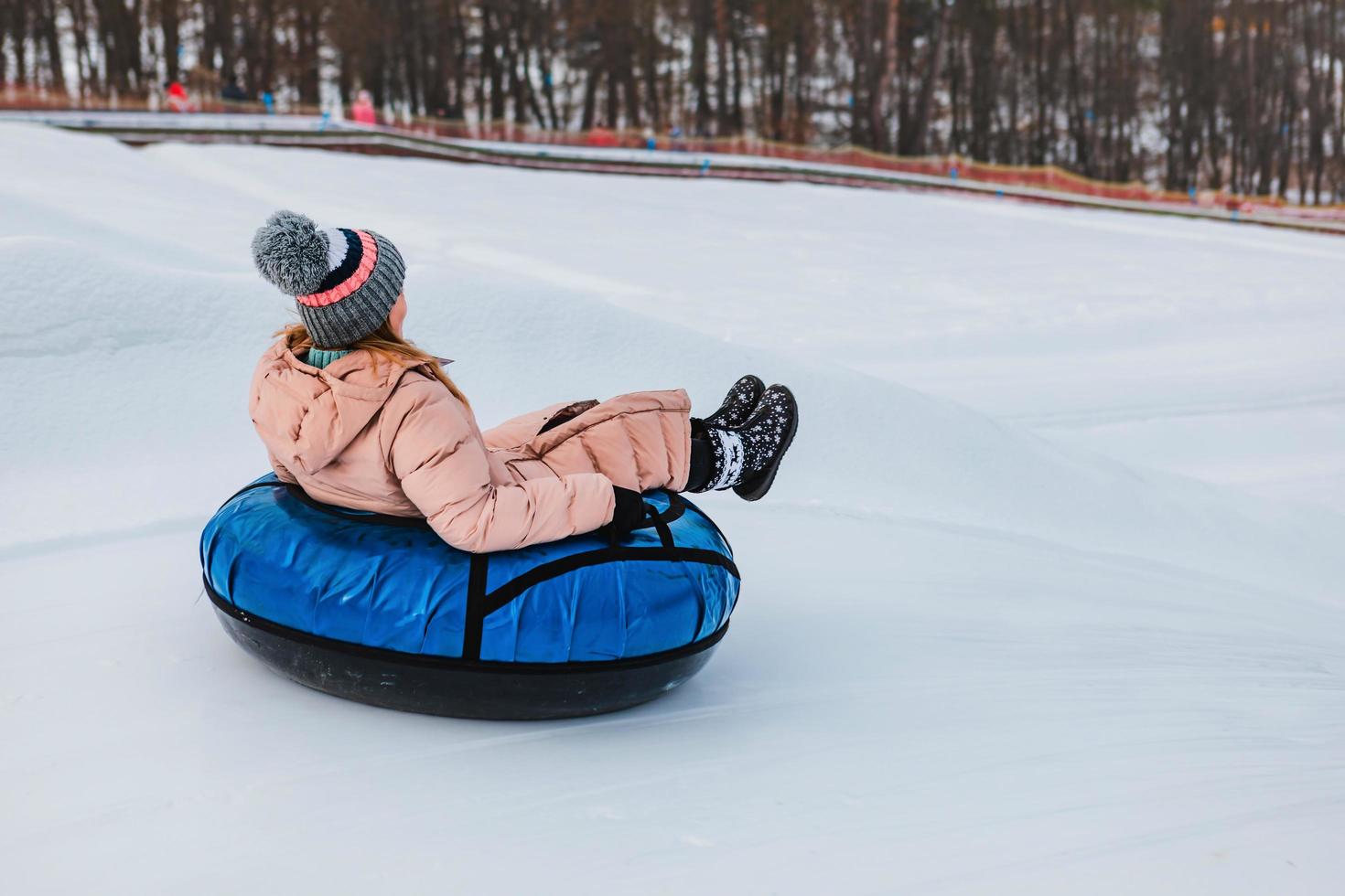 människor som åker snöslangar på vinterparken foto