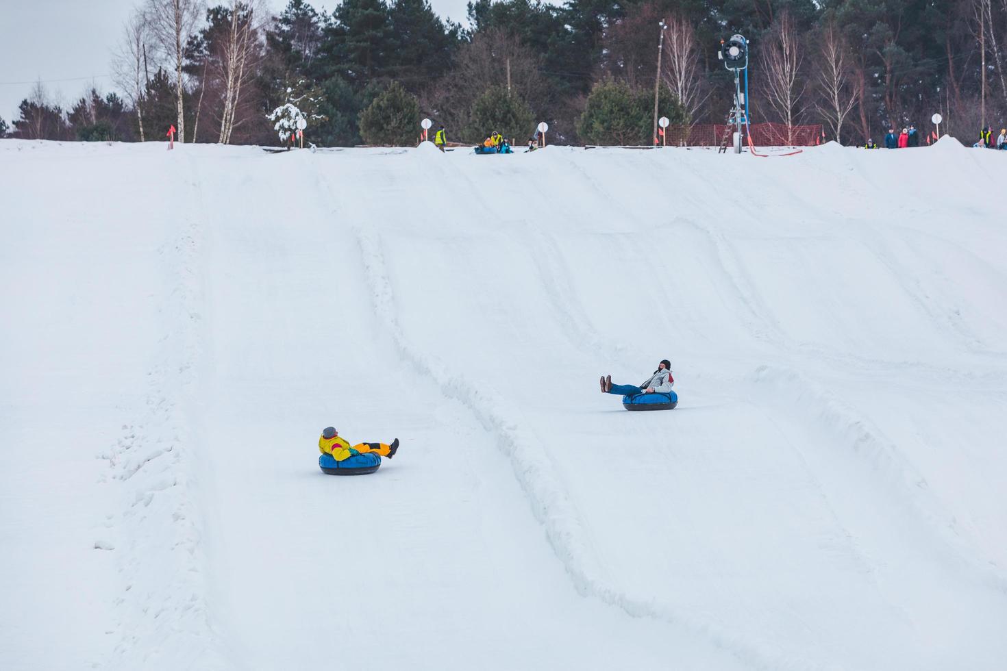 människor som åker snöslangar på vinterparken foto