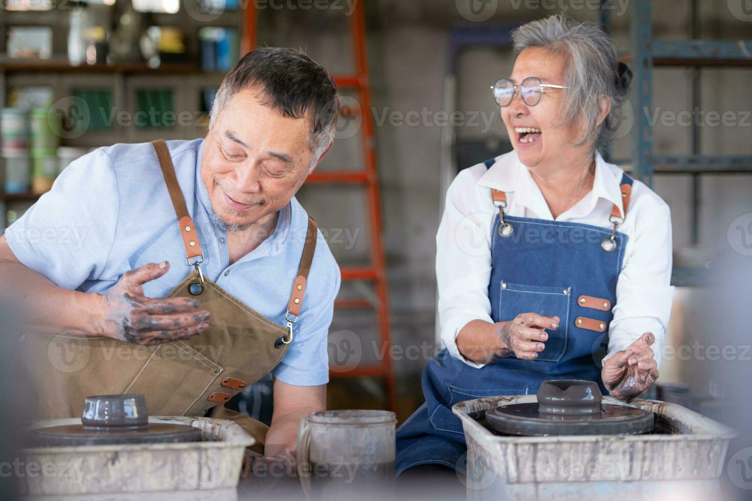 porträtt av en senior asiatisk par håller på med aktiviteter tillsammans i de krukmakeri verkstad. foto