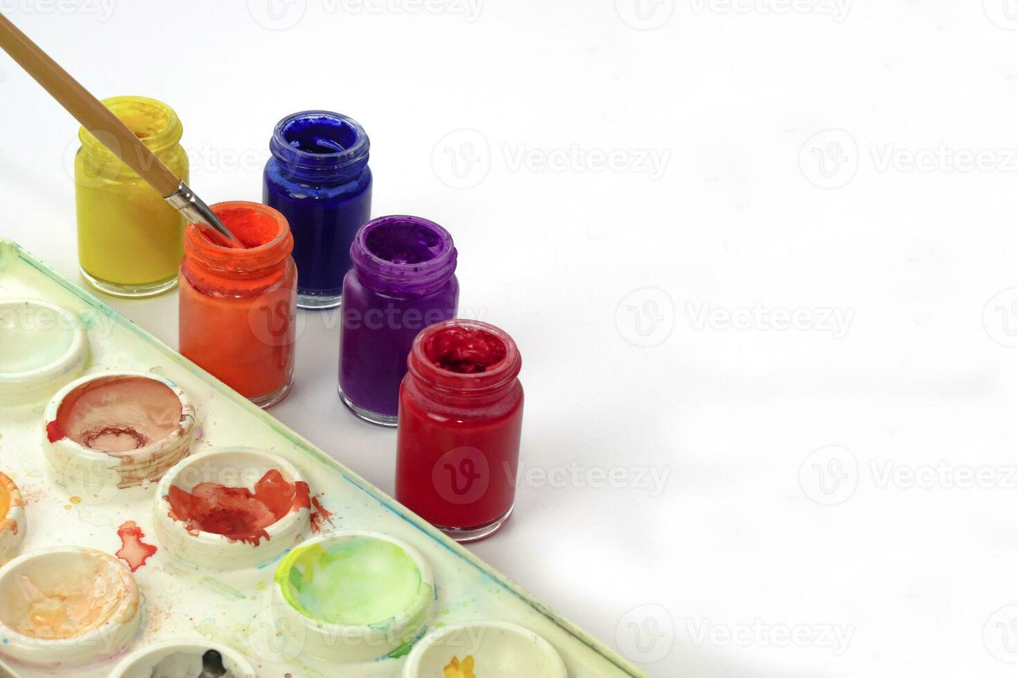 vattenfärg bricka, paintbrush och vattenfärg flaskor på vit bakgrund. inlärning och målningar konst begrepp. foto