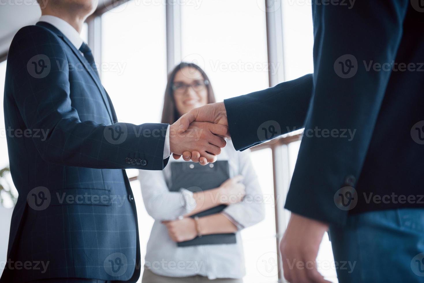 två självsäkra affärsmän skakar hand under ett möte på kontoret, framgång, hantering, hälsning och partner koncept foto