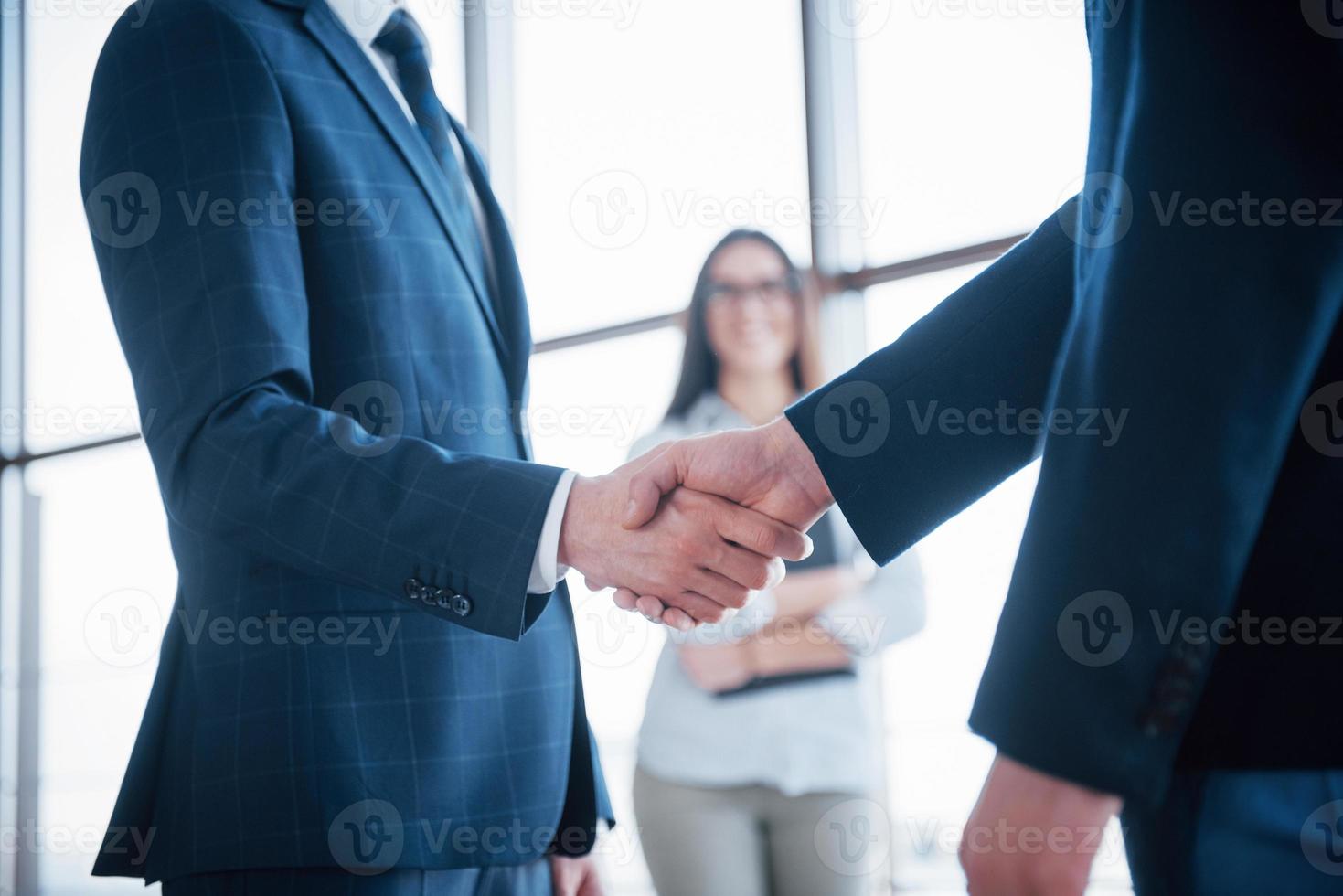 två självsäkra affärsmän skakar hand under ett möte på kontoret, framgång, hantering, hälsning och partner koncept foto
