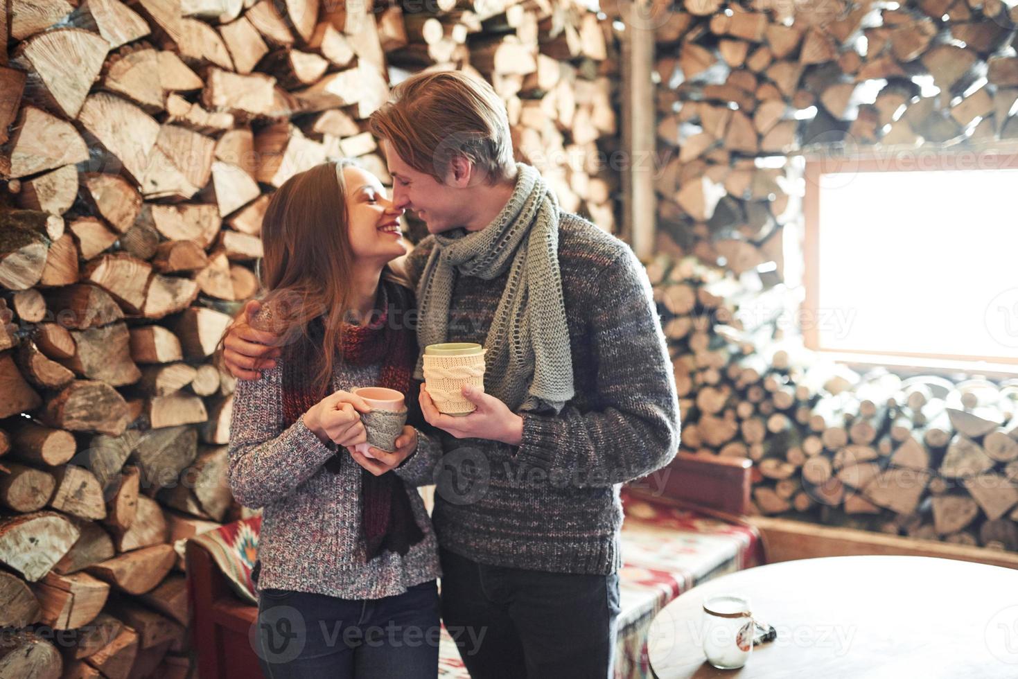 foto av glad man och vacker kvinna med koppar utomhus på vintern. vintersemester och semester. julpar av lycklig man och kvinna dricker varmt vin. par i kärlek