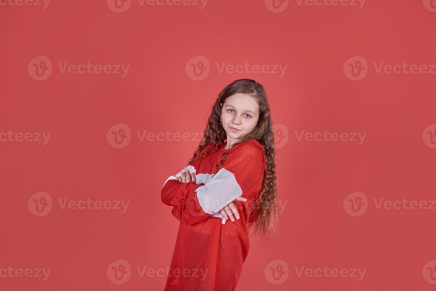 ung urban kvinna dansar på röd bakgrund, modern smal hip-hop stil tonårsflicka foto