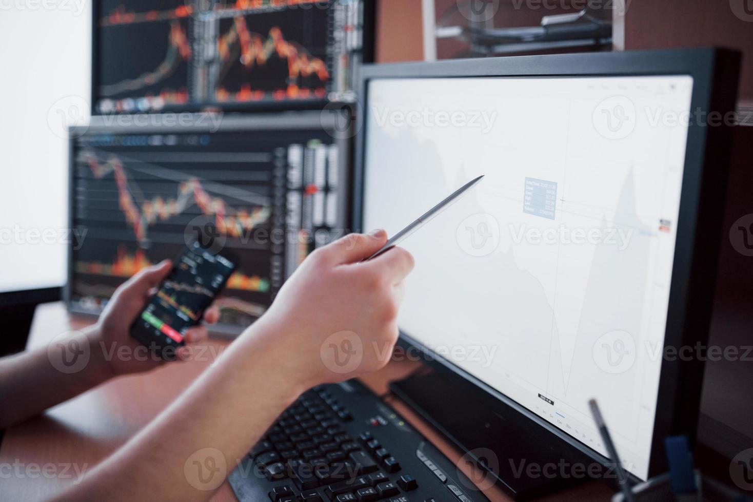 analysera data. närbild av ung affärsman som pekar på data som presenteras i diagrammet med penna medan han arbetar på kreativa kontor foto