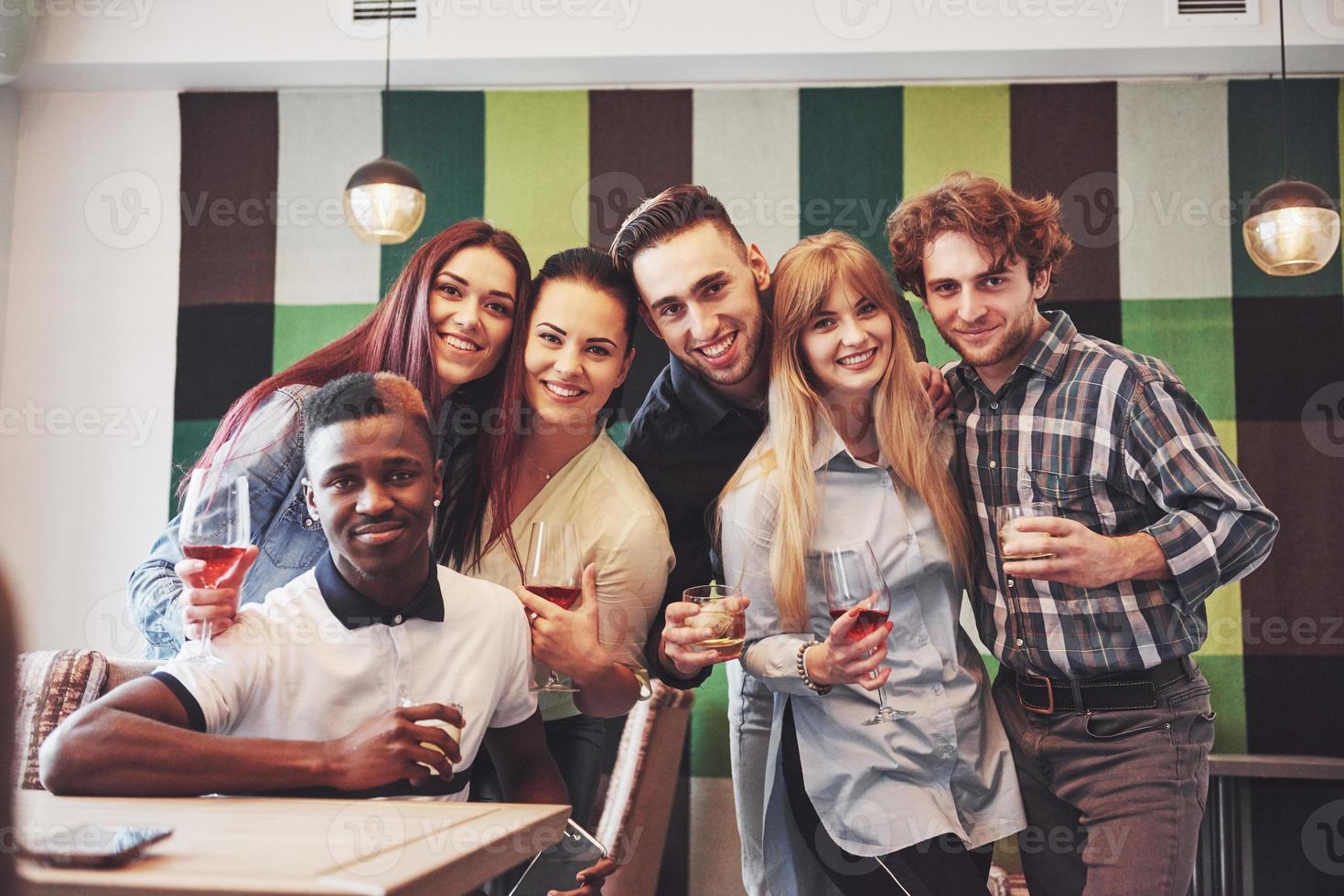 mångrasiga människor som har roligt på kaféet tar en selfie med mobiltelefonen. grupp unga vänner som sitter på restaurang foto