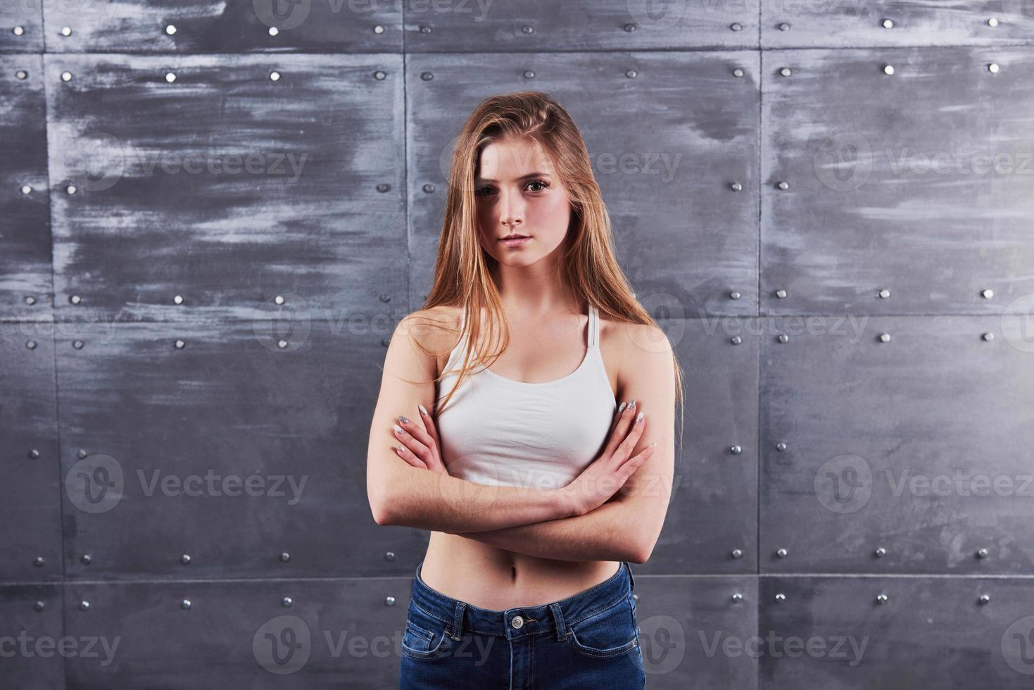 bild av ung kvinna mot grå studiobakgrund foto