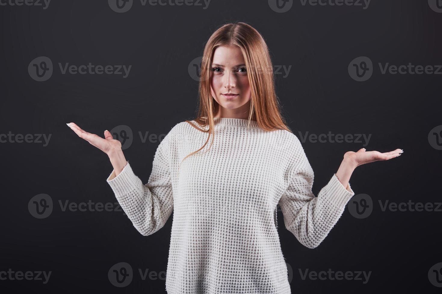 närbild porträtt av vacker ung kvinna i vit tröja och jeans, isolerad på svart bakgrund foto