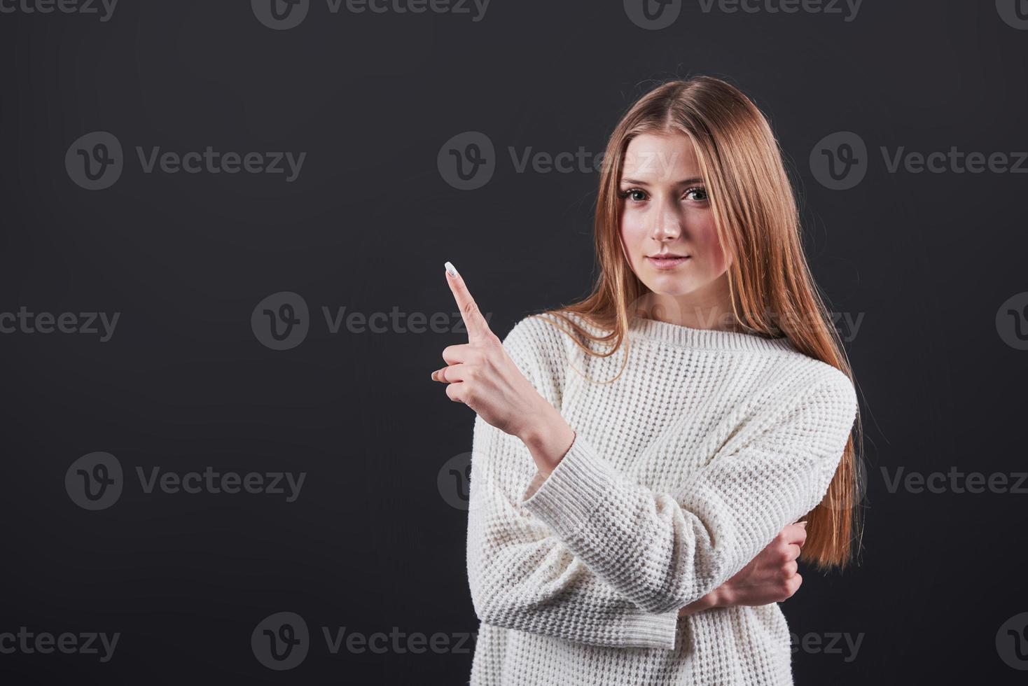 närbild porträtt av vacker ung kvinna i vit tröja och jeans, isolerad på svart bakgrund foto