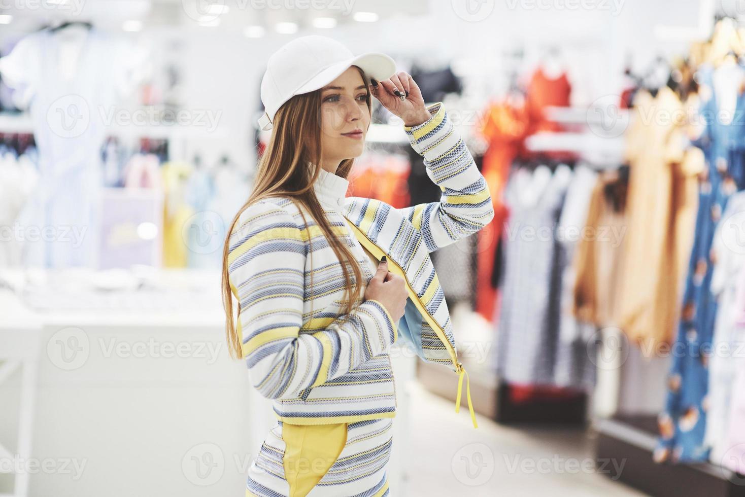 kvinna som handlar kläder. shoppare tittar på kläder inomhus i butik. vacker glad leende asiatisk kaukasisk kvinnlig modell foto