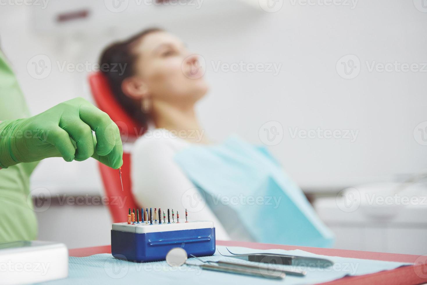 en patient på en tandklinik sitter i en stol och läkaren förbereder verktygen för behandling foto