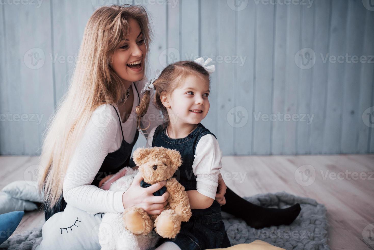 lycklig kärleksfull familj. mamma och hennes dotter barn flicka leker och kramas foto