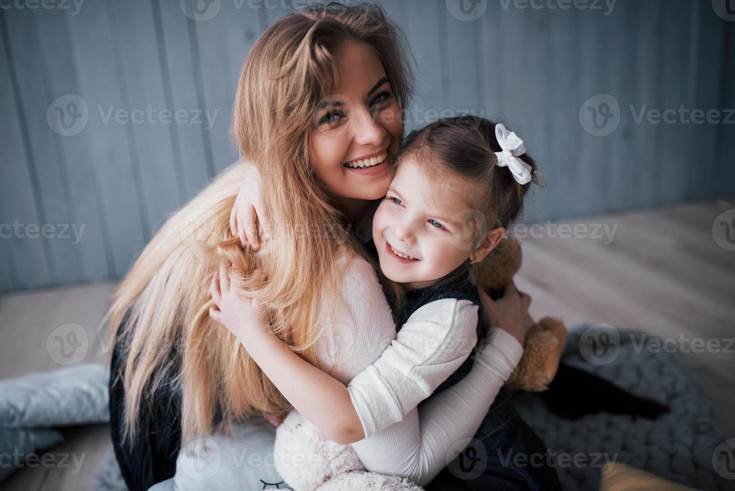 lycklig kärleksfull familj. mamma och hennes dotter barn flicka leker och kramas foto