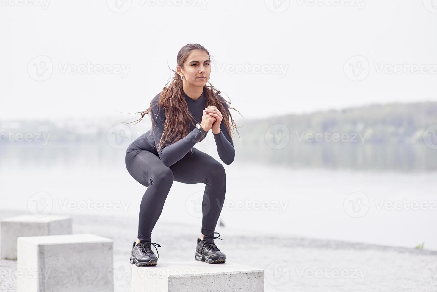 fitness sport kvinnor i mode sportkläder gör yoga fitness träning i stadsgatan över grå betong bakgrund på kusten foto