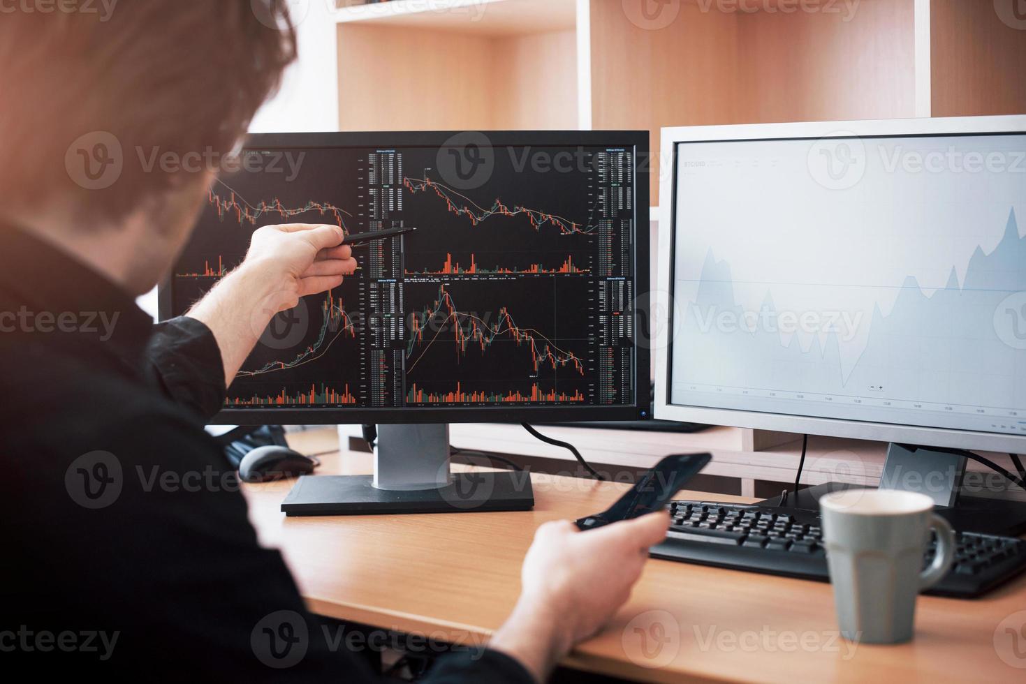 analysera data. närbild av ung affärsman som pekar på data som presenteras i diagrammet med penna medan han arbetar på kreativa kontor foto