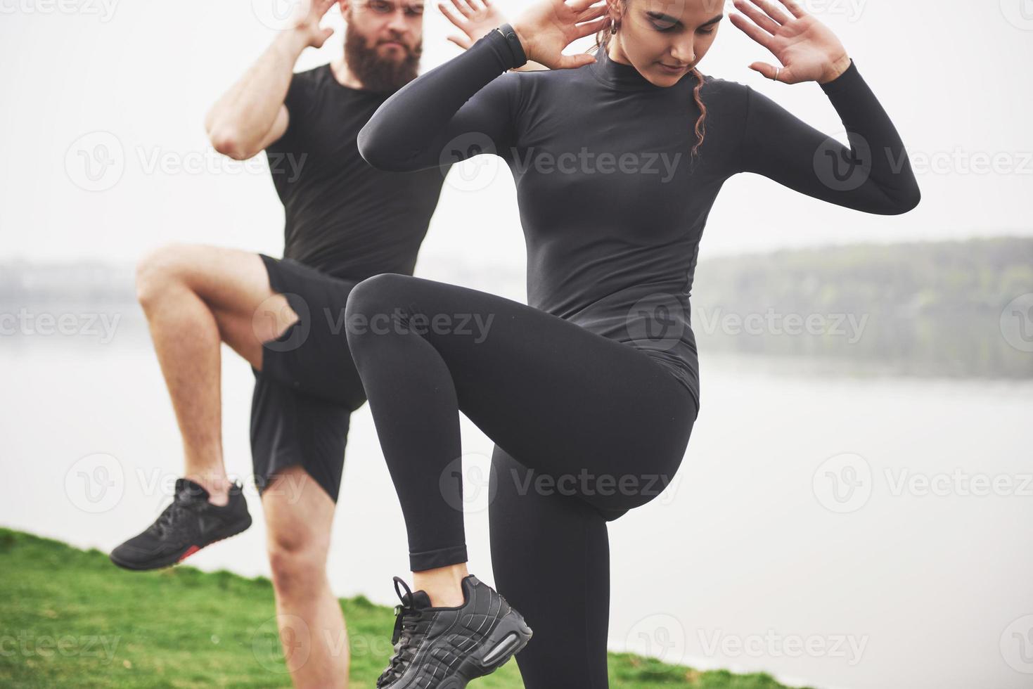 ett ungt par tycker om att spela sport på morgonen i det fria. värm upp före träning foto