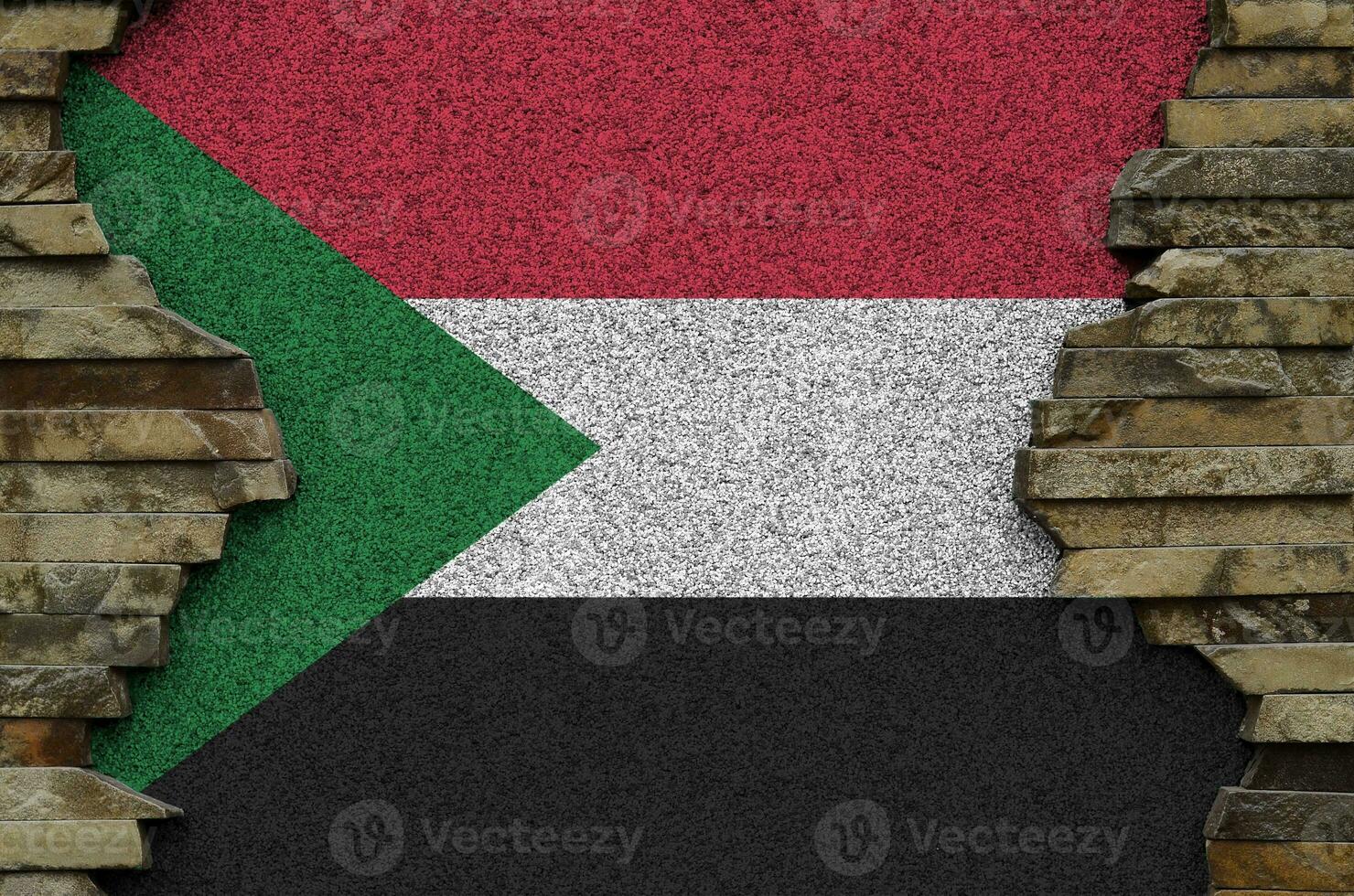 sudan flagga avbildad i måla färger på gammal sten vägg närbild. texturerad baner på sten vägg bakgrund foto