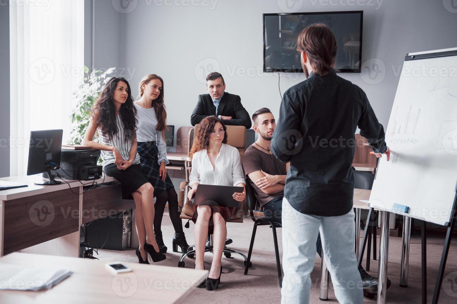 glada unga kollegor diskuterar i möte på kreativa kontor foto