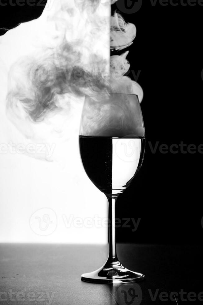 en glas av vatten och rök på en svart och vit bakgrund foto