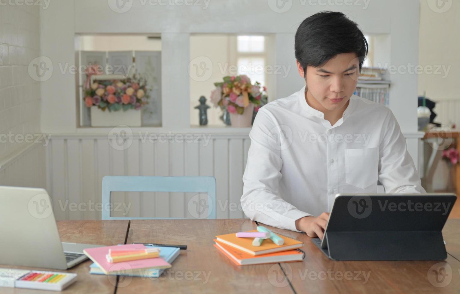 manliga studenter använder bärbar dator för att studera sommaren online hemma. foto