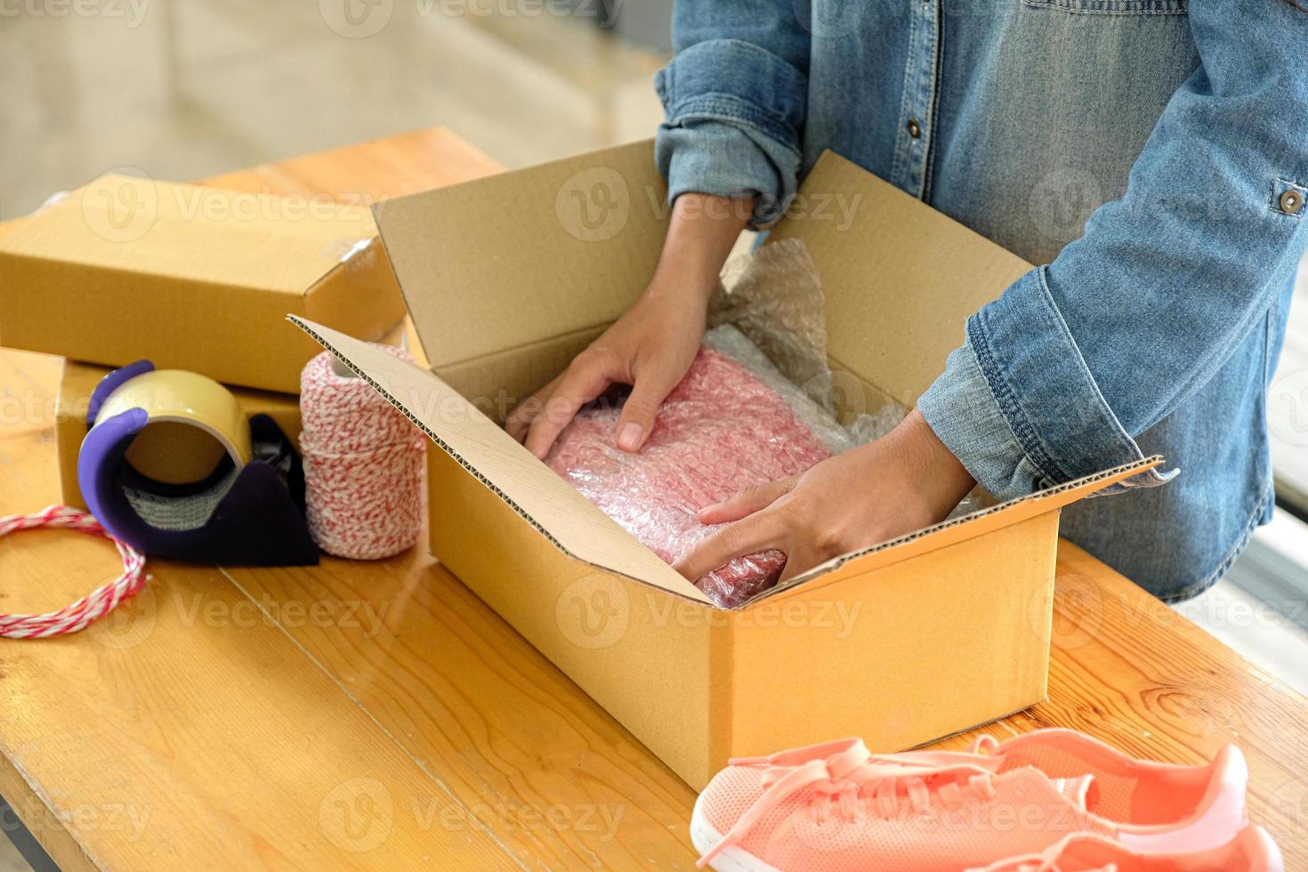 online -säljare packar skor i lådor för att leverera till kunder. foto