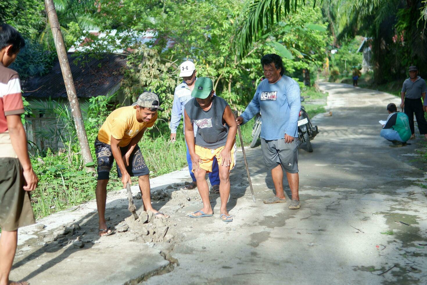 kuaro kalimantan timur, indonesien 11 november 2023. de by gemenskap var sett arbetssätt tillsammans till reparera de skadad väg foto