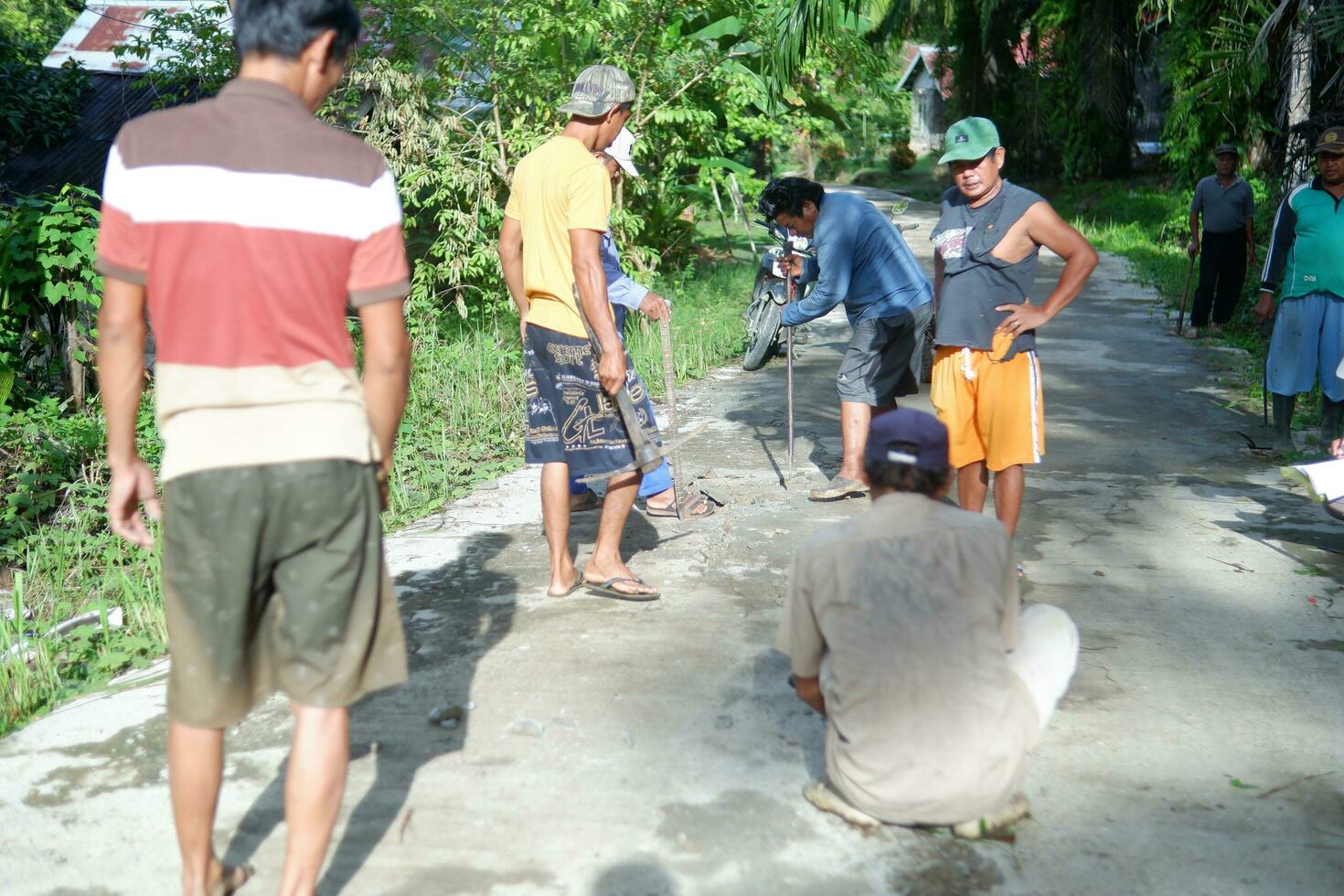 kuaro kalimantan timur, indonesien 11 november 2023. de by gemenskap var sett arbetssätt tillsammans till reparera de skadad väg foto