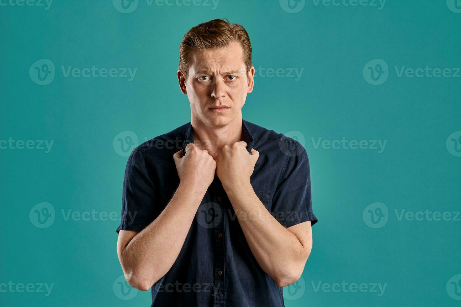 närbild porträtt av en ingefära kille i Marin t-shirt Framställ på blå bakgrund. uppriktig känslor. foto