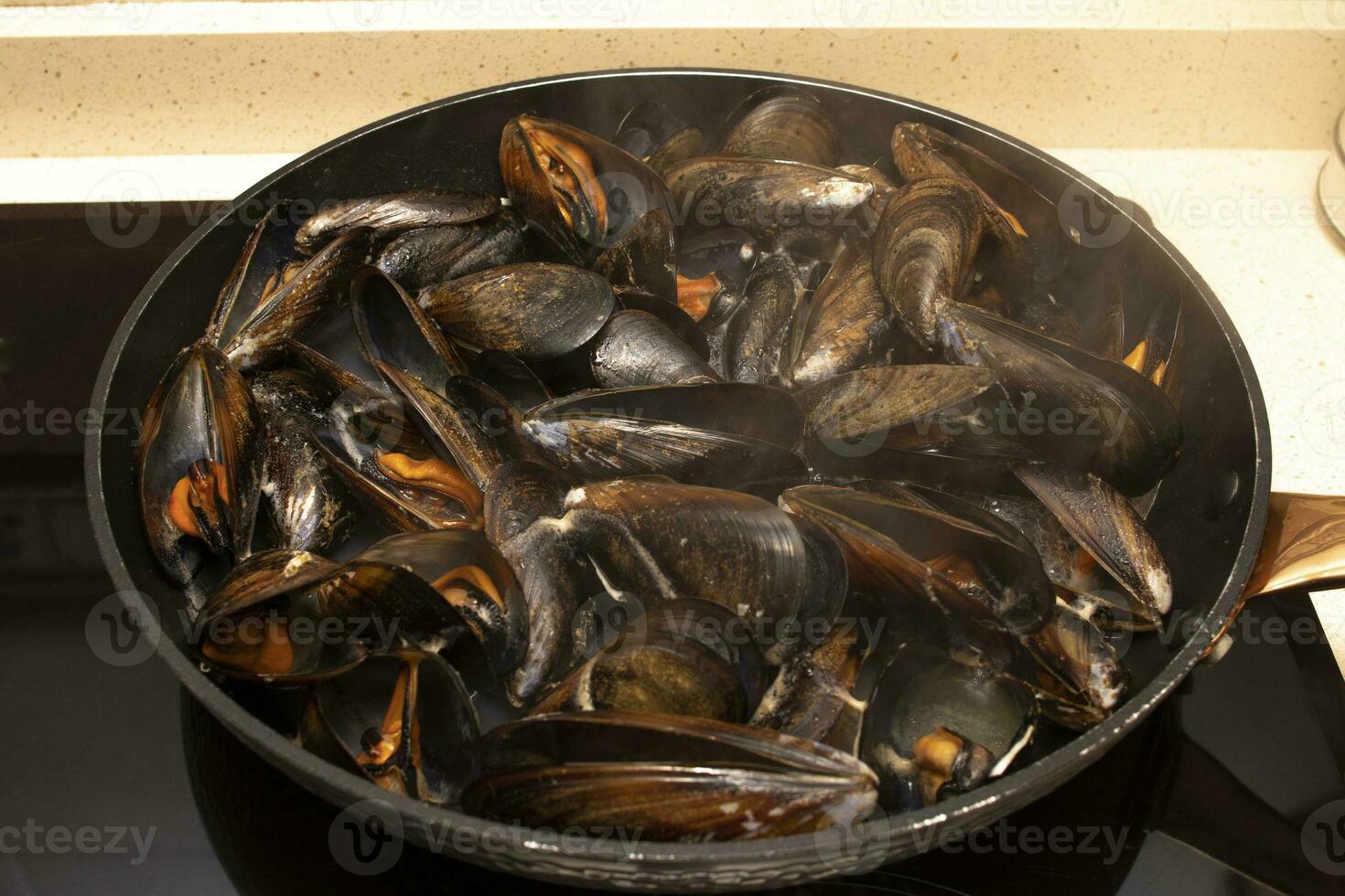 matlagning musslor i en panorera. musslor är perfekt i ändlös fisk recept, men de enklaste och mest traditionell i galicia är ångad musslor. foto