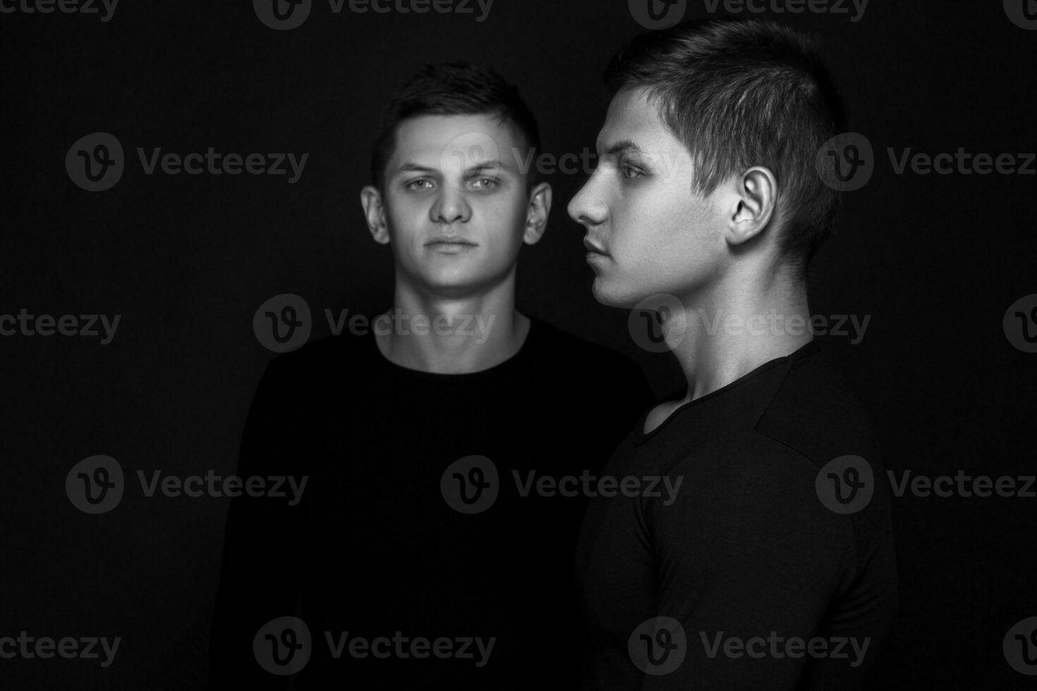 två attraktiv positiv ung tvilling bröder stående klädd i foto