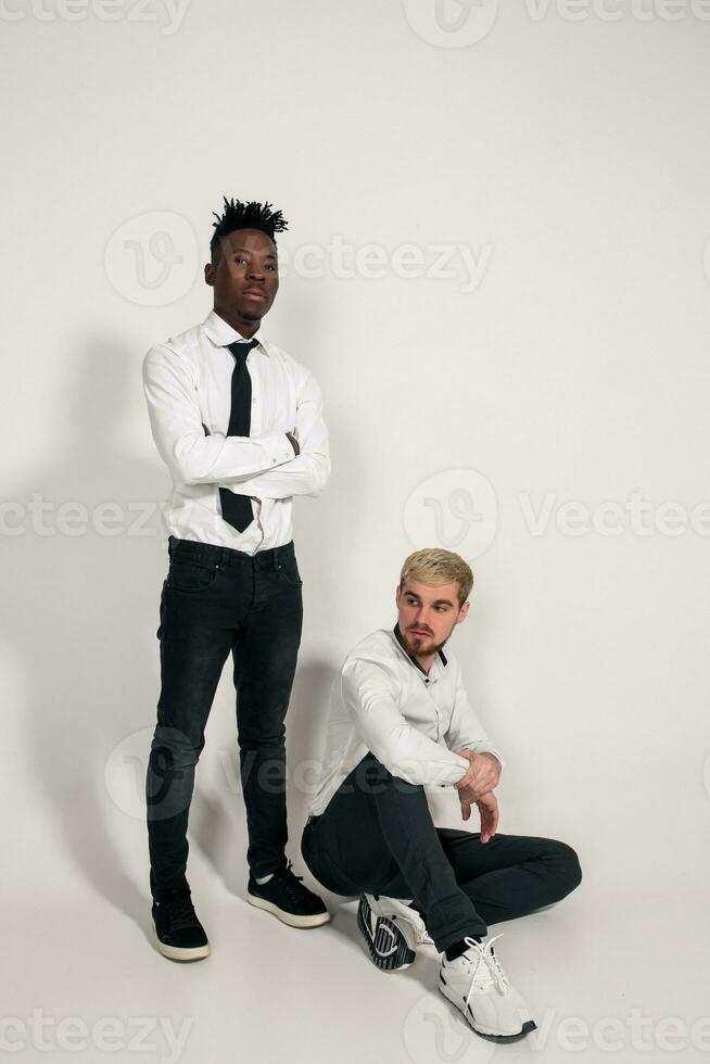 två eleganta män Framställ och har roligt på vit bakgrund. foto