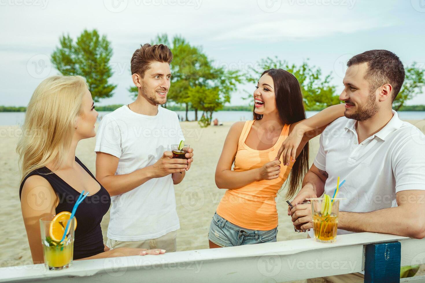 vänner har roligt på de bar utomhus, dricka cocktails. foto