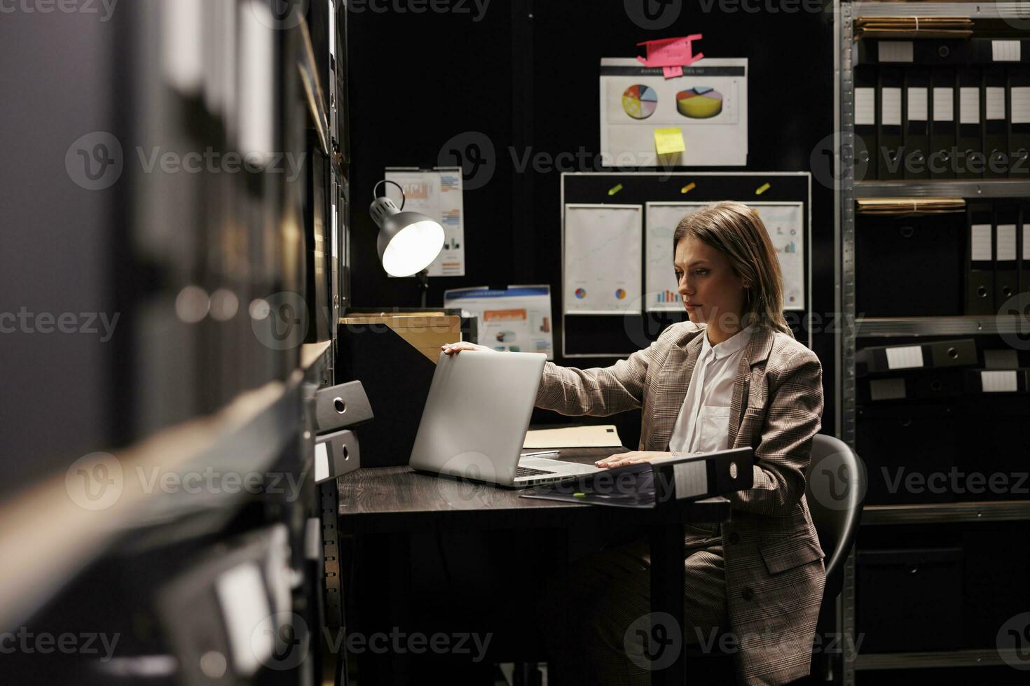 affärskvinna framställning till lämna kontor efter arbetssätt sent på natt på företags- administrativ Rapportera i arkiv rum. kvinna anställd analyserar byråkrati dokument, sökande företag systemet. foto