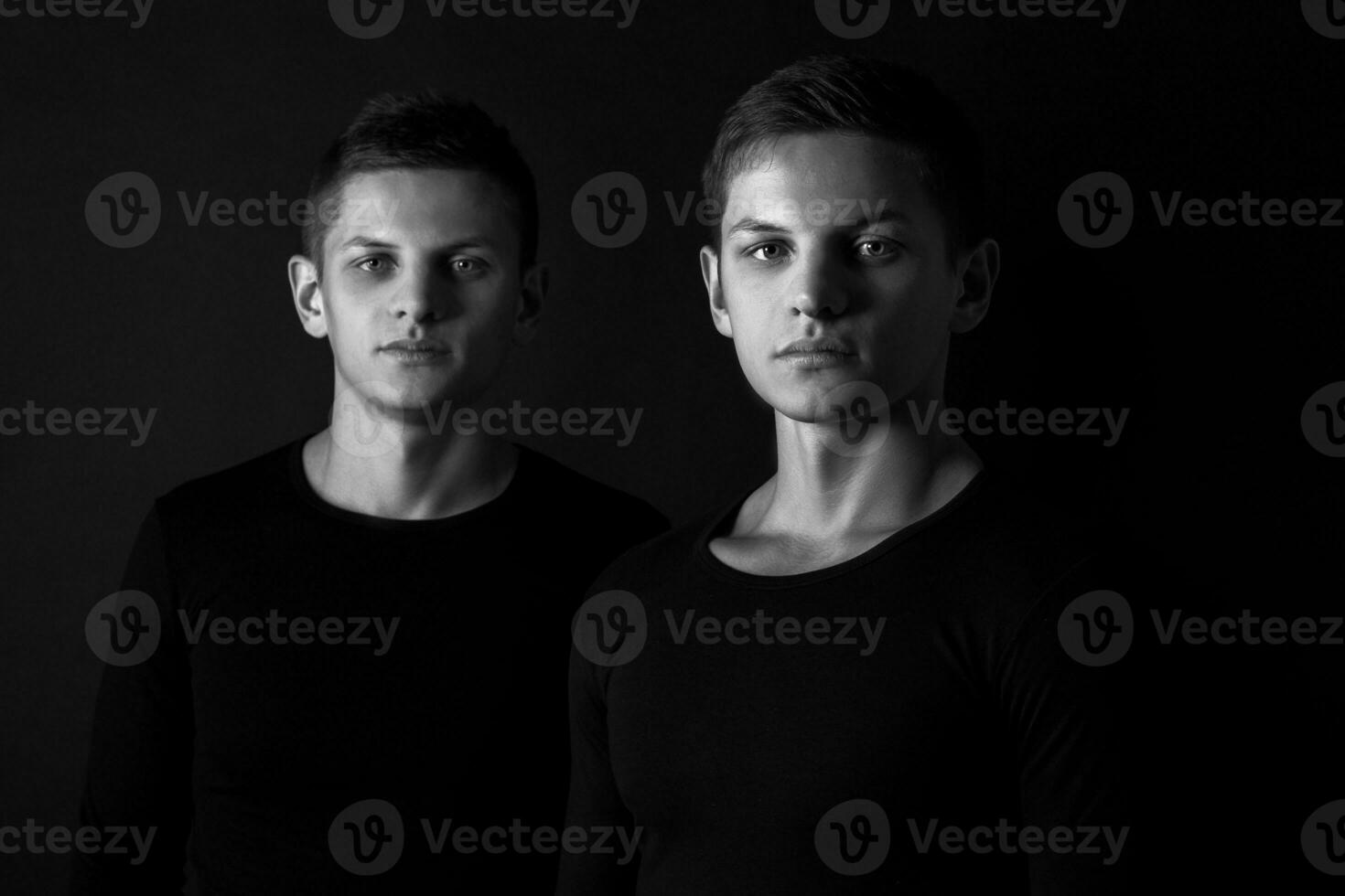 två attraktiv positiv ung tvilling bröder stående klädd i foto