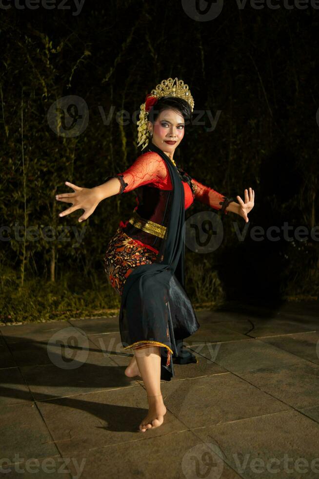 en javanese dansare dans med guld Tillbehör och en ansikte full av smink foto