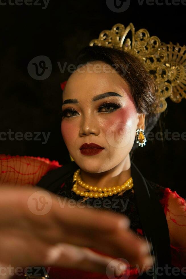 ett asiatisk dansare förvånar de publik i en kulturell konst prestanda i röd kostymer foto