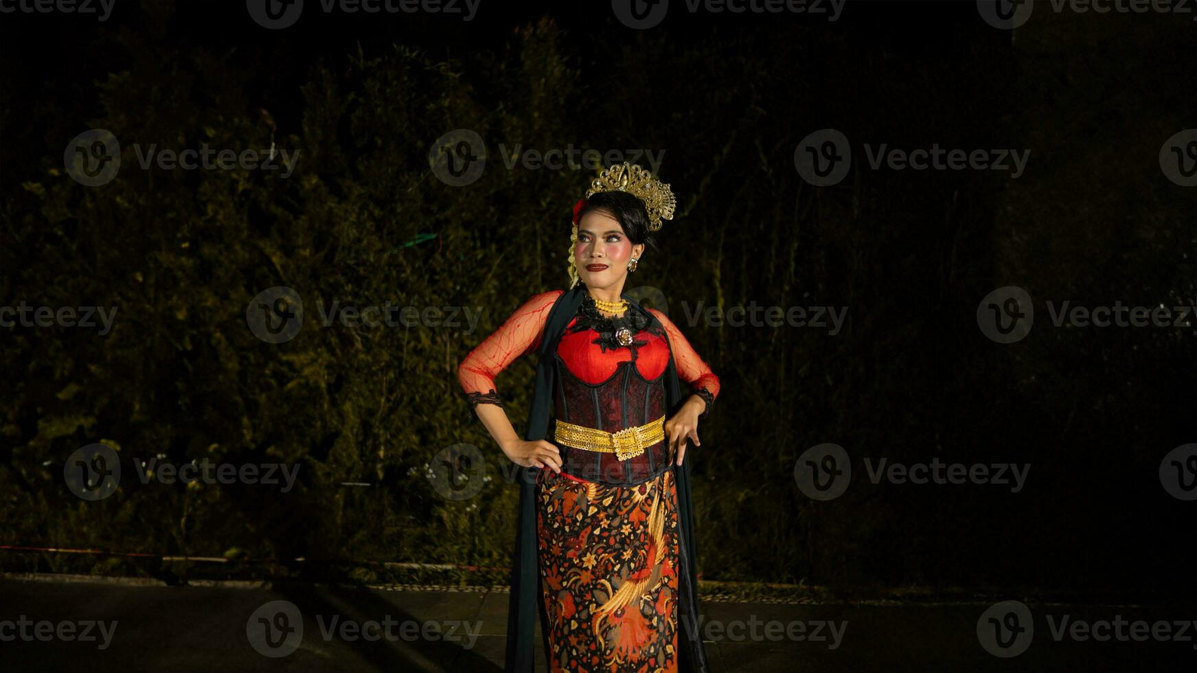 en balinesisk dansare bär en röd klänning med konstnärlig detaljer den där Lägg till unikhet till henne utseende foto