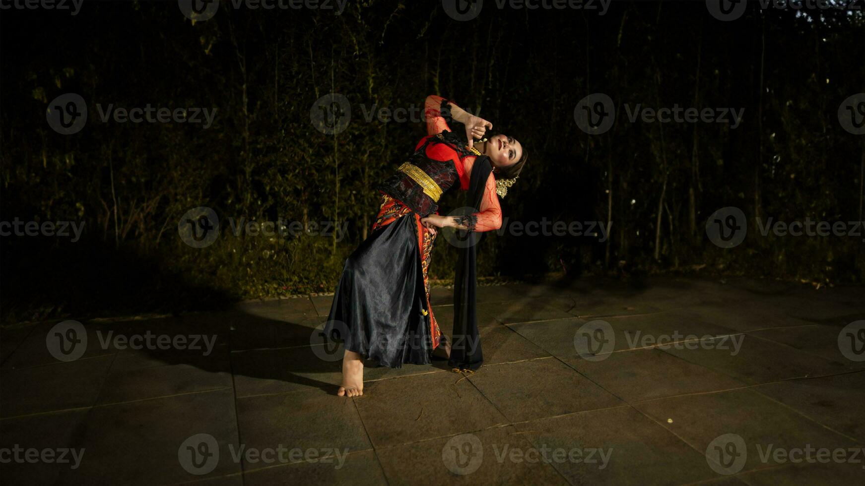 en javanese dansare i en röd kostym presenteras en dansa den där fängslad de publik med hans skicklighet foto