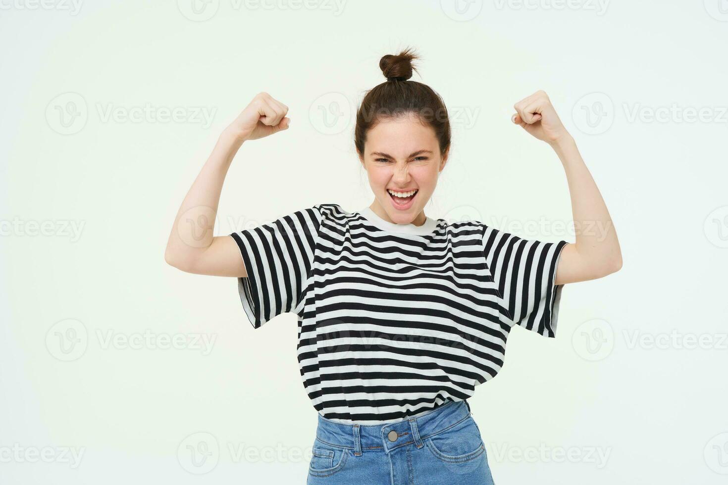 bild av fräck, stark och självsäker kvinna visar henne muskler, böjning biceps, höjning henne vapen hög, stående över vit bakgrund foto