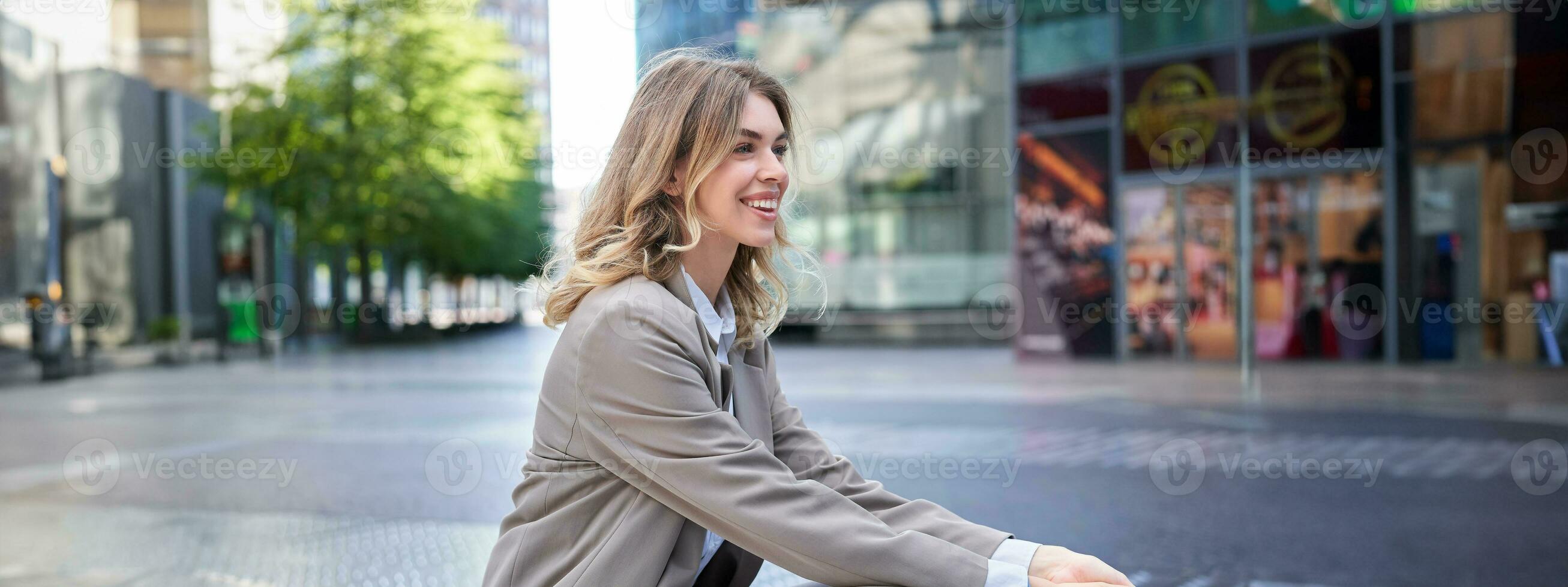 affärskvinna ler som sitter i stad Centrum, bär beige kostym för kontor arbete foto