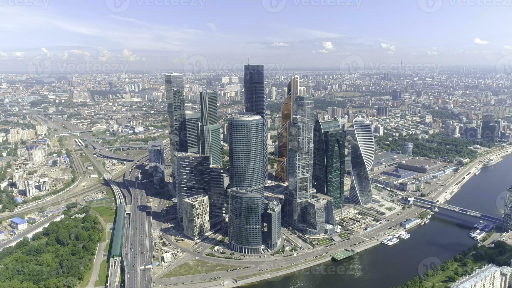 topp se av företag Centrum med skyskrapor på bakgrund av panorama av stad. handling. stadsbild med hisnande visningar av speglad skyskrapor på bakgrund blå himmel och flod foto