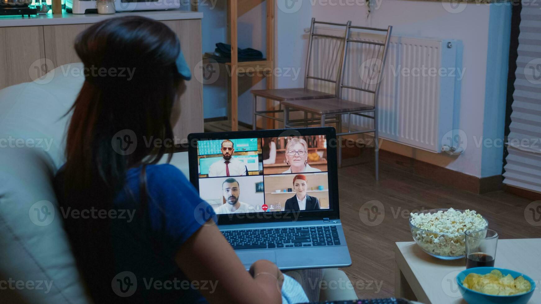 frilansare har virtuell konversation med kollegor på bärbar dator Sammanträde på soffa i pyjamas. avlägsen arbetstagare diskuterar under uppkopplad möte hört med team på videosamtal använder sig av internet teknologi foto