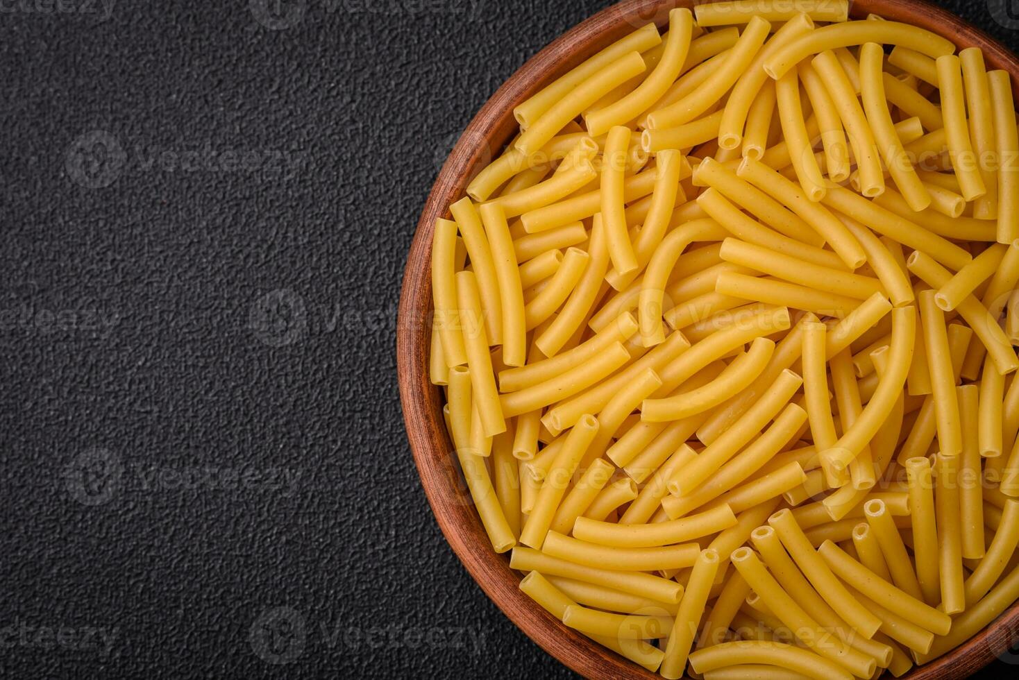 rå hela spannmål vete pasta med salt och kryddor i en keramisk tallrik foto