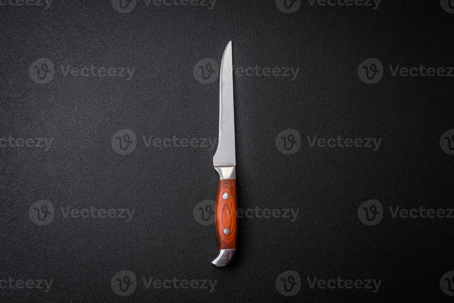kök kniv tillverkad av stål på en mörk texturerad bakgrund foto