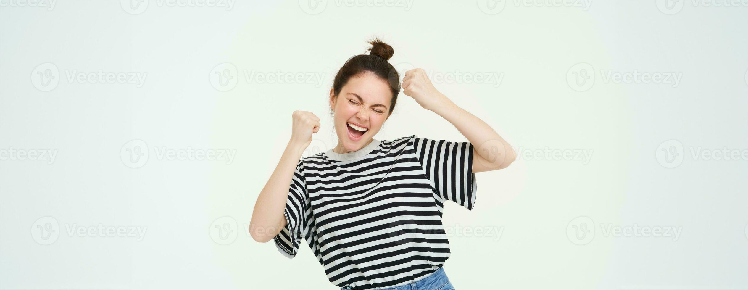 bild av upphetsad ung flicka glädjande, höjning händer upp, skriker från spänning och lycka, vinnande, fira seger, stående över vit bakgrund foto